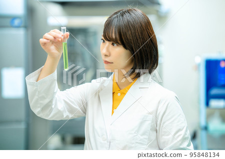 A woman in a white coat doing research A woman in a white coat doing research 95848134