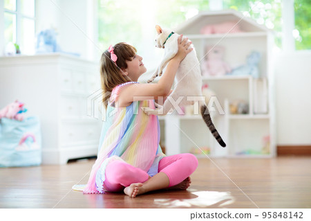 Child playing with cat at home. Kids and pets. 95848142