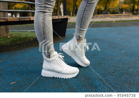 Stylish woman in white shoes on city street 95848738