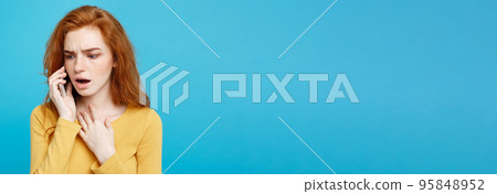 Portrait of a surprised confused woman in yellow casual calling mobile phone isolated over blue background Portrait of a surprised confused woman in yellow casual calling mobile phone isolated over blue background 95848952