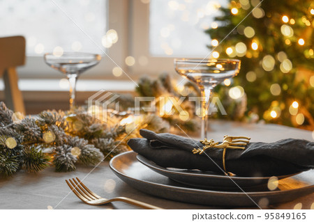 Christmas festive table setting, gold decorate and champagne. Family holiday dinner or New Year party. 95849165