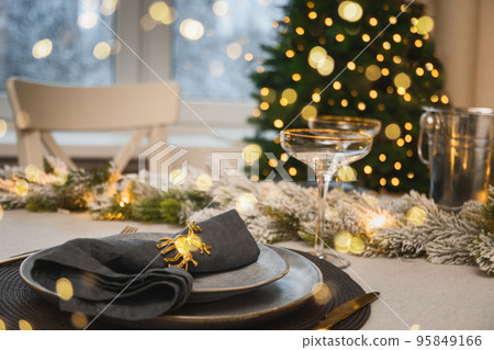 Christmas festive table setting, gold decorate and champagne. Family holiday dinner or New Year party. Christmas festive table setting, gold decorate and champagne. Family holiday dinner or New Year party. 95849166