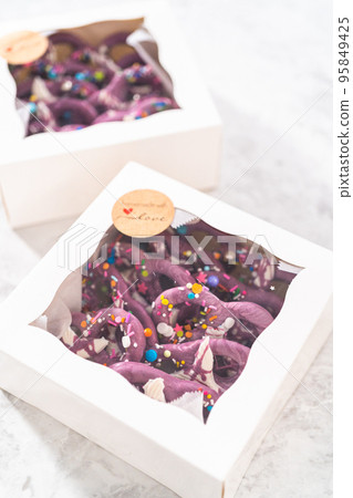 Packaging homemade mermaid pretzel twists into a white paper box. Packaging homemade mermaid pretzel twists into a white paper box. 95849425