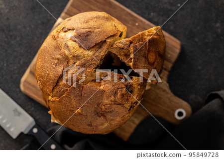 Panettone Christmas Cake. Italian sweet bread on black kichen table. Top view. Panettone Christmas Cake. Italian sweet bread on black kichen table. Top view. 95849728