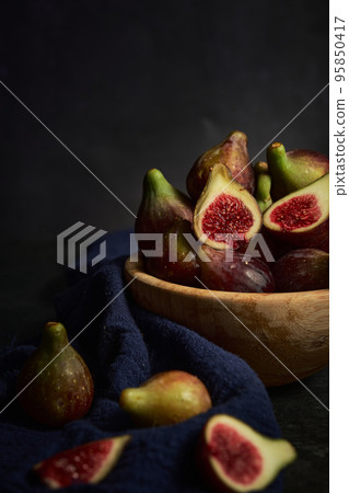 juicy fig berries in a wooden bowl 95850417