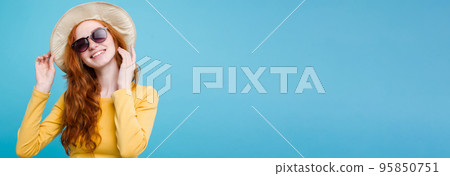 Travel concept - Close up Portrait young beautiful attractive redhair girl wtih trendy hat and sunglass smiling. Blue Pastel Background. Copy space 95850751