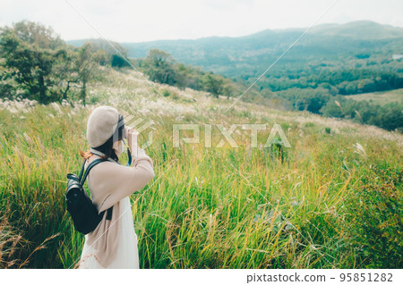 Photo of a woman holding a camera in nature Photo of a woman holding a camera in nature 95851282