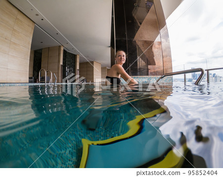 Young woman on bicycle simulator underwater in the pool 95852404