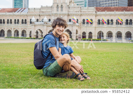 Dad and son on background of Merdeka square and Sultan Abdul Samad Building. Traveling with children concept 95852412