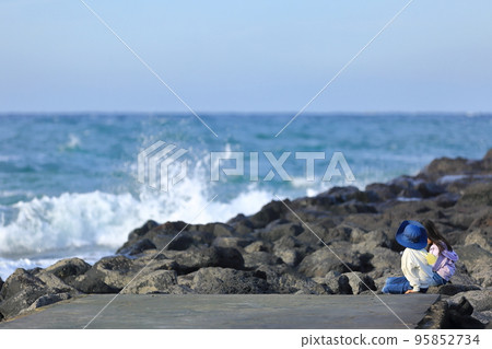 A couple of children watching the cool waves of the beautiful sea A couple of children watching the cool waves of the beautiful sea 95852734