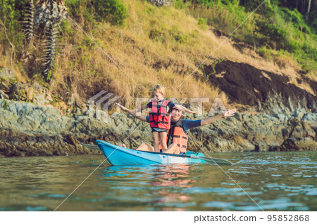 Father and son kayaking at tropical ocean. Father and son kayaking at tropical ocean. 95852868