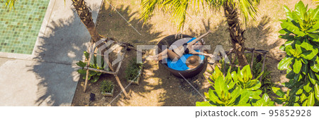 Girl in sun loungers among palm trees near the swimming pool BANNER, long format Girl in sun loungers among palm trees near the swimming pool BANNER, long format 95852928