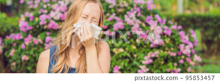 Pollen allergy concept. Young woman is going to sneeze. Flowering trees in background BANNER, long format Pollen allergy concept. Young woman is going to sneeze. Flowering trees in background BANNER, long format 95853457