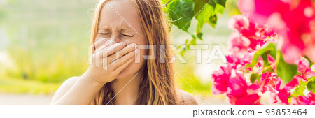 Pollen allergy concept. Young woman is going to sneeze. Flowering trees in background BANNER, long format Pollen allergy concept. Young woman is going to sneeze. Flowering trees in background BANNER, long format 95853464