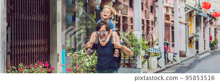 Dad and son are tourists on the Street in the Portugese style Romani in Phuket Town. Also called Chinatown or the old town BANNER, long format 95853516