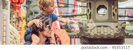 Dad and son are tourists on the Street in the Portugese style Romani in Phuket Town. Also called Chinatown or the old town BANNER, long format 95853517
