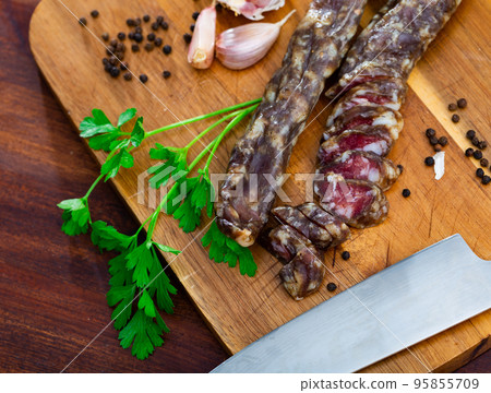 Dry pork sausage with condiments on table 95855709