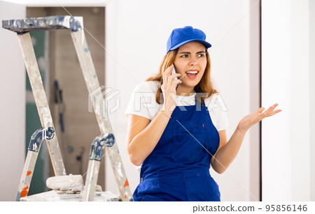 Young woman builder having quarrel during phone call Young woman builder having quarrel during phone call 95856146