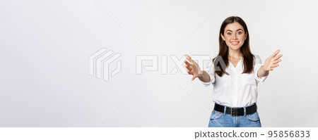 Enthusiastic laughing woman, smiling and stretching out arms forward, welcome you, greeting, standing over white background 95856833