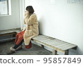 一名身穿大衣的女士在巴士候車室暖手 95857849