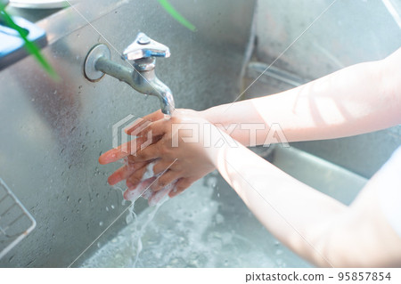 在水龍頭下洗手的人的手 在水龍頭下洗手的人的手 95857854