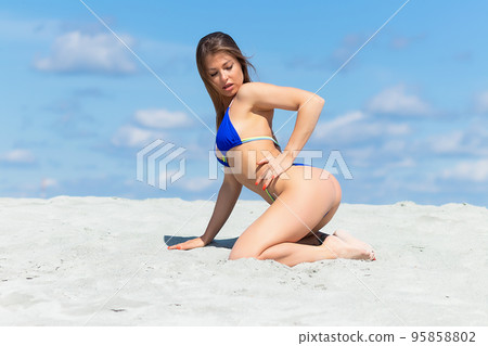 Graceful woman in bikini on sandy beach 95858802