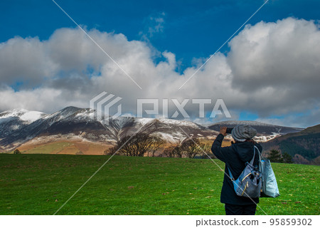 A woman who stands to take pictures of the scenery A woman who stands to take pictures of the scenery 95859302