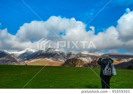 A woman who stands to take pictures of the scenery A woman who stands to take pictures of the scenery 95859303