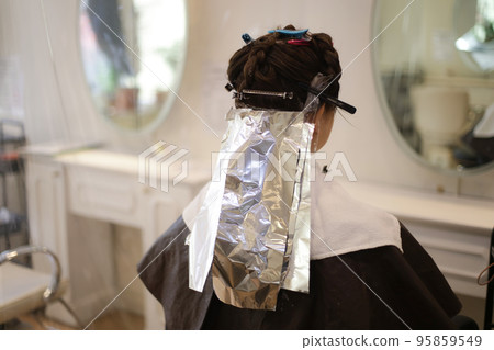 Woman dyeing her hair at a beauty salon Woman dyeing her hair at a beauty salon 95859549