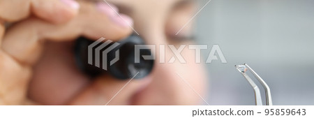 Jeweller examine polished diamond through magnifying glass, diamond jewellery under grading Jeweller examine polished diamond through magnifying glass, diamond jewellery under grading 95859643