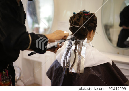 Male hairdresser coloring woman's hair 95859699