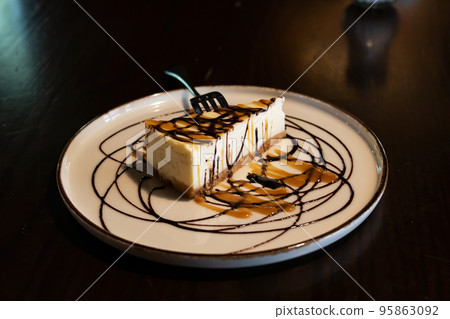 Cake with chocolate syrup on a plate 95863092