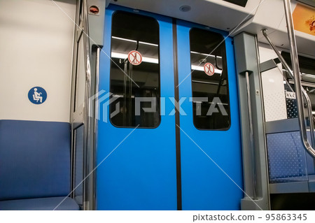 The doors in the subway car are blue The doors in the subway car are blue 95863345