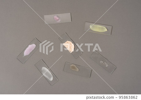 Smears of face cosmetics on laboratory glass on a gray background. The concept of research and creation of cosmetics 95863862