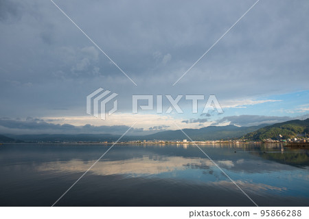 Blue sky and clouds reflected on the surface of the lake in the morning Blue sky and clouds reflected on the surface of the lake in the morning 95866288