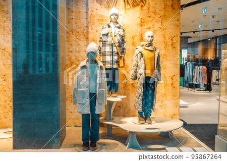 Female mannequins wear luxury style winter clothes. Female mannequins in shop window. Display of a clothing store 95867264