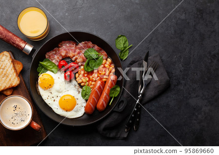 English breakfast with fried eggs, beans, bacon and sausages English breakfast with fried eggs, beans, bacon and sausages 95869660