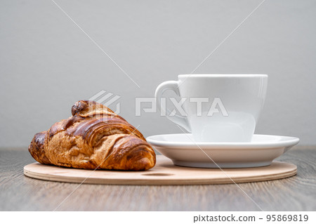 coffee and croissant on a wooden tray on the table coffee and croissant on a wooden tray on the table 95869819
