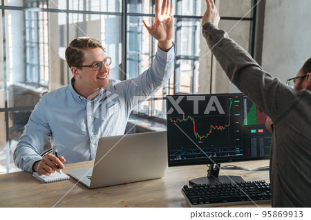 Two partners crypto trade investors giving high five to each other after fulfilling good deal Two partners crypto trade investors giving high five to each other after fulfilling good deal 95869913
