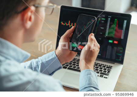 Cropped picture of man with phone checking chart of cryptocurrency, weighing risks of investment 95869946