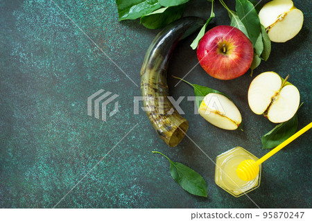 Background Rosh hashanah (Jewish New Year). Traditional holiday symbols - shofar, honey and apple on a stone or slate background. Top view flat lay background, copy space. Background Rosh hashanah (Jewish New Year). Traditional holiday symbols - shofar, honey and apple on a stone or slate background. Top view flat lay background, copy space. 95870247