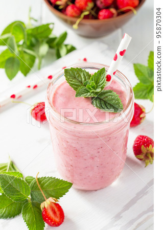 Strawberry milkshake or smoothie on a white wooden background. Healthy juicy vitamin drink diet or vegan food concept. 95870304