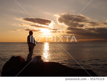 The sunset over Sagami Bay, the silhouette of a black sea bream angler standing on the shore aiming for the early evening. 95870328