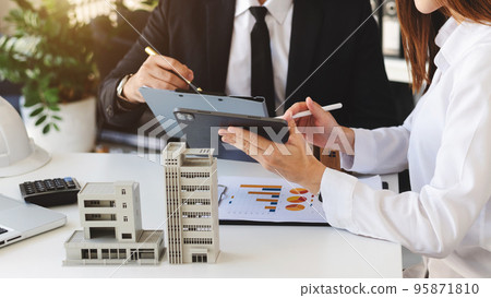 Real estate broker agent presenting and consult to customer to decision making sign insurance form agreement, home model, concerning mortgage loan office Real estate broker agent presenting and consult to customer to decision making sign insurance form agreement, home model, concerning mortgage loan office 95871810