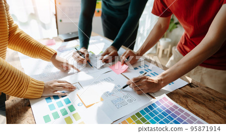 UX developer and ui designer brainstorming about mobile app interface wireframe design with customer breif and color code at office.. UX developer and ui designer brainstorming about mobile app interface wireframe design with customer breif and color code at office.. 95871914