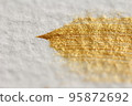 Close up of golden brush strokes on watercolor paper 95872692