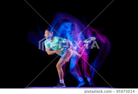 Studio shot of professional tennis player playing tennis isolated over dark background in mixed neon light. Concept of motion, speed, professional sport. Studio shot of professional tennis player playing tennis isolated over dark background in mixed neon light. Concept of motion, speed, professional sport. 95873014