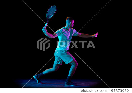 Young sportive man, professional tennis player in motion, action isolated over dark background in neon light. Concept of professional sport, competition, skills. Young sportive man, professional tennis player in motion, action isolated over dark background in neon light. Concept of professional sport, competition, skills. 95873080