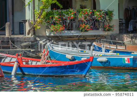 Idyllic Limone sul Garda pier with colorful boats at summer, Italian alps Idyllic Limone sul Garda pier with colorful boats at summer, Italian alps 95874011