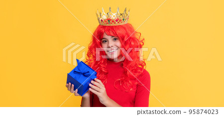 cheerful kid in crown with present box on yellow background 95874023